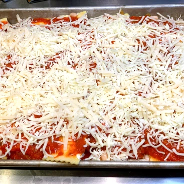 Sheet ravioli with sauce and cheese
