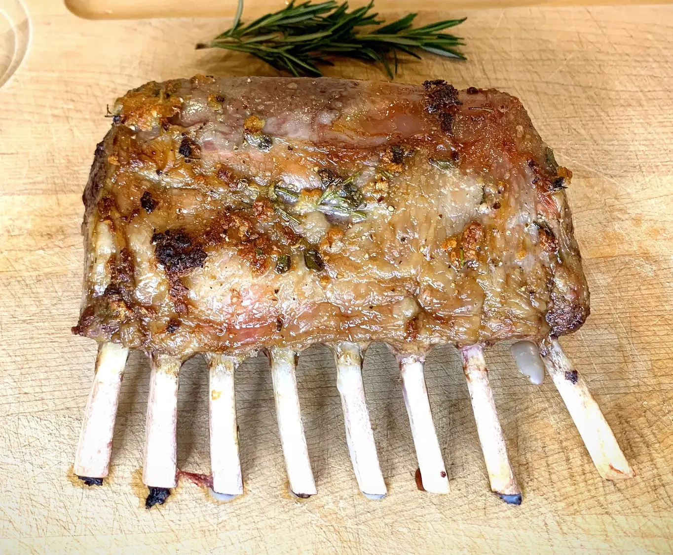 cooked lamb chops on cutting board with sprig of rosemary