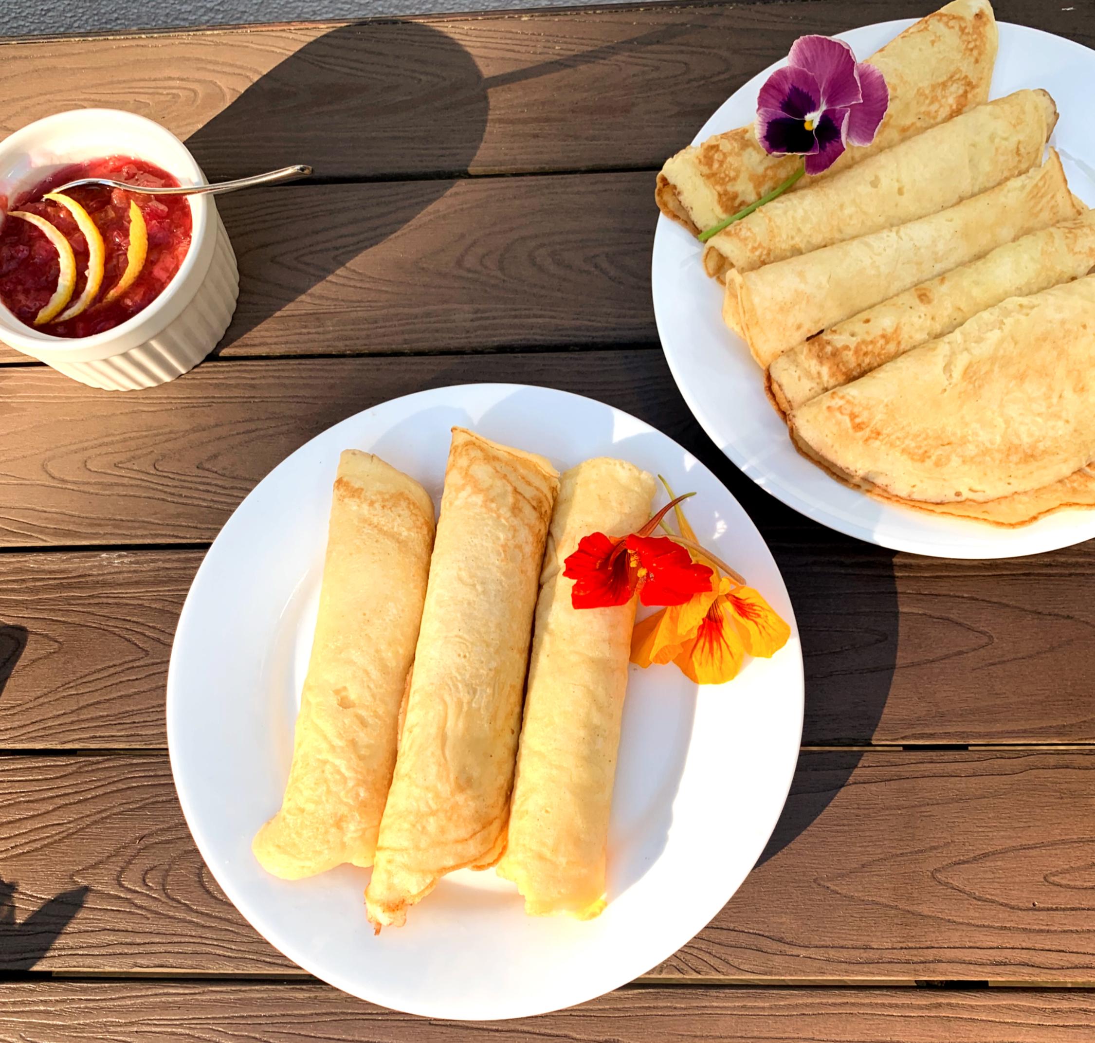 thin pancakes rolled and plated with flower garnish