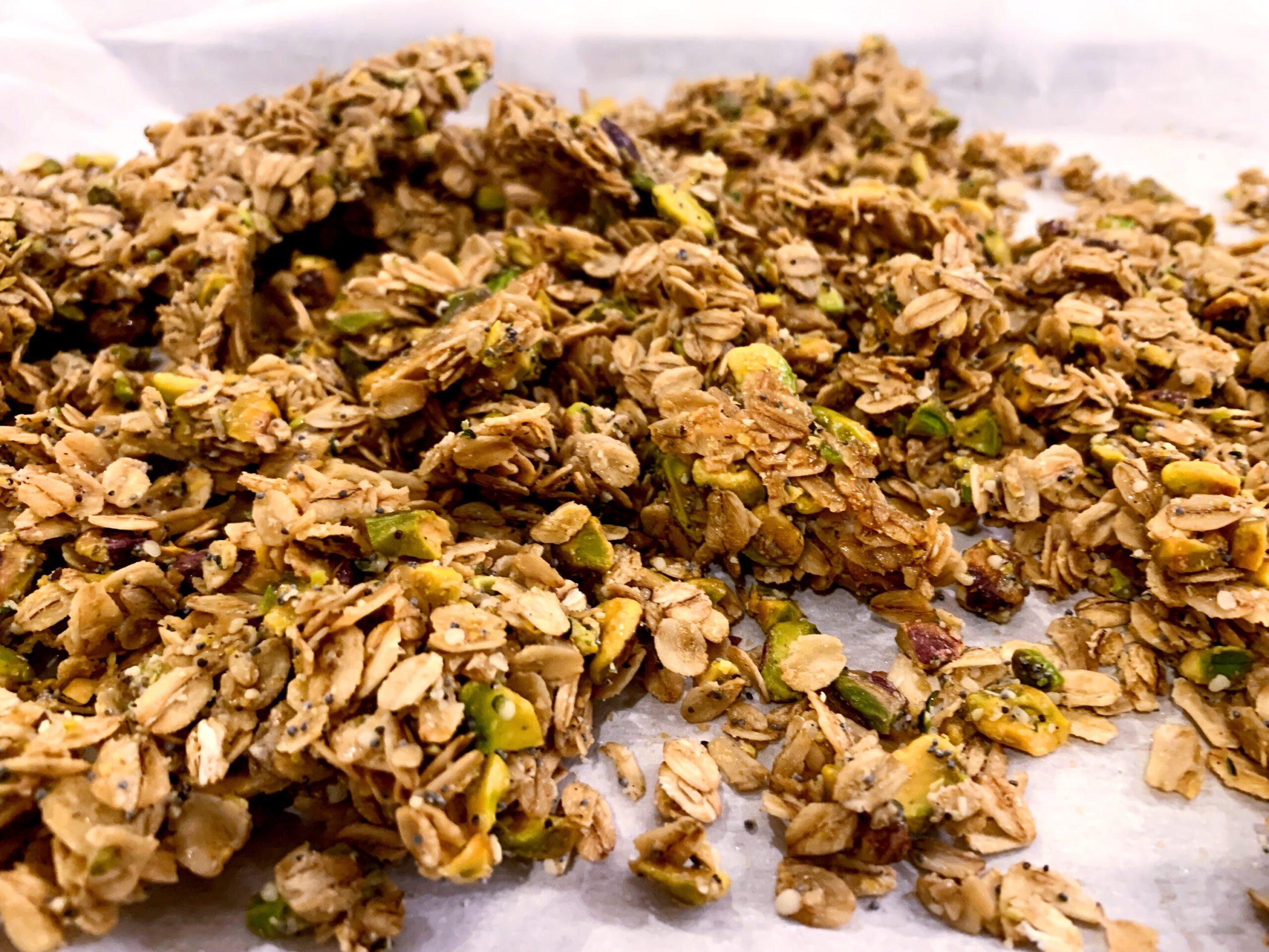 Salted Lemon Pistachio Granola spread out on parchment paper