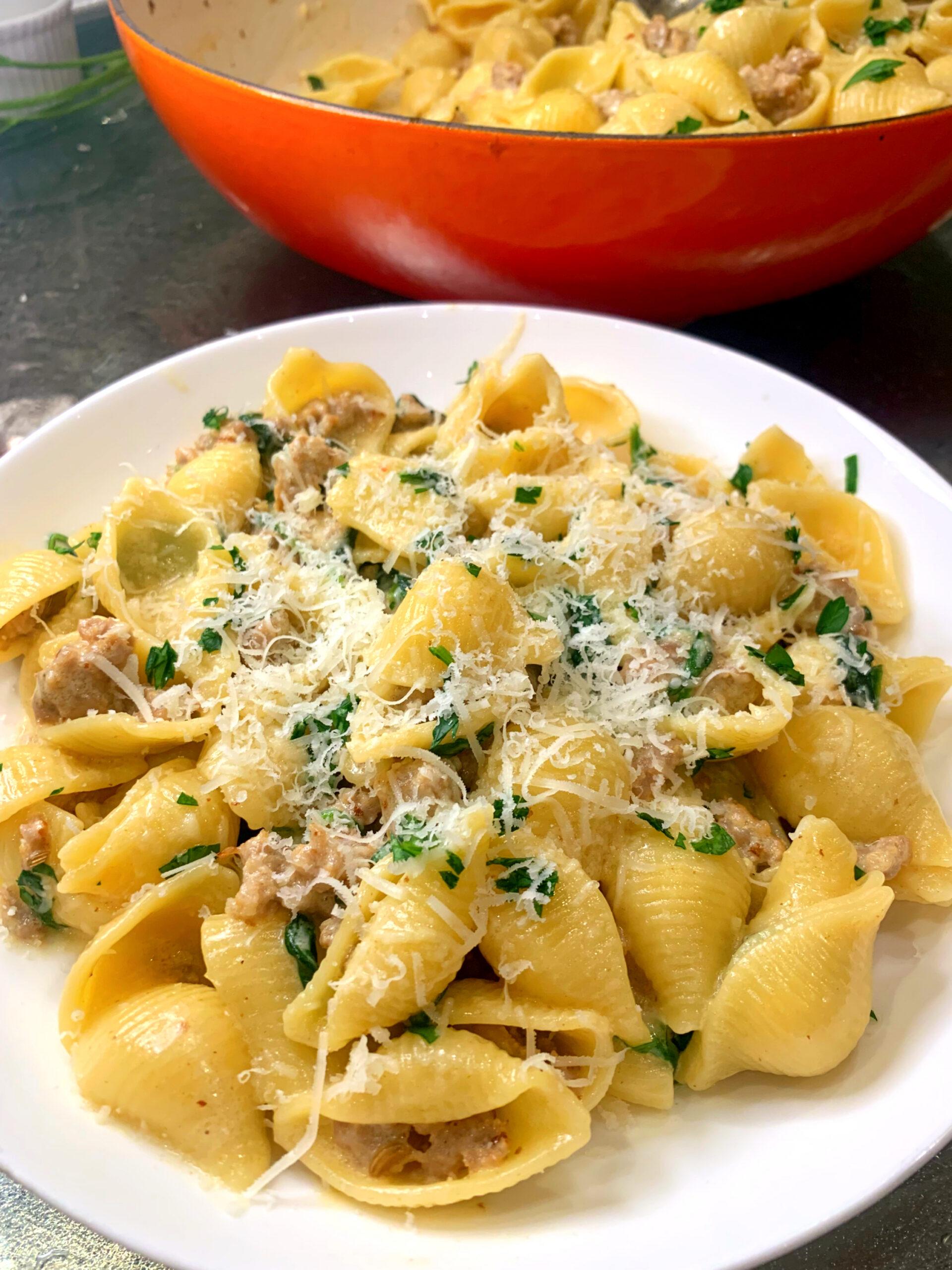 Pasta Bowl filled with Sausage Alfredo. Serving bowl behind it.